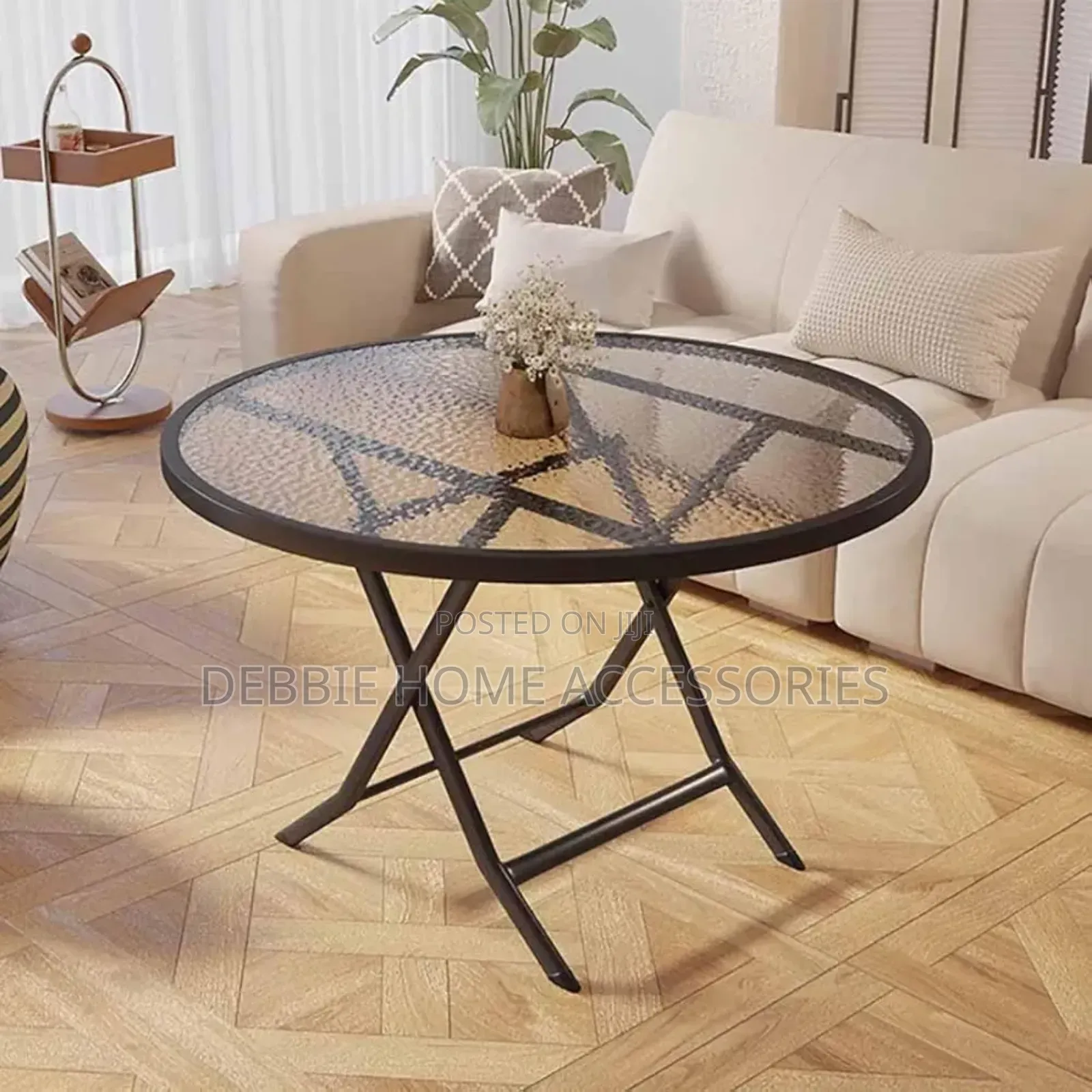 Round Folding Table With a Tempered Glass Top and a Black Metal Frame.