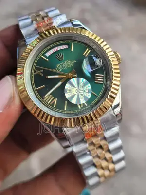 Rolex Day-Date Watch With a Green Dial and a Two-Tone Metal Bracelet.