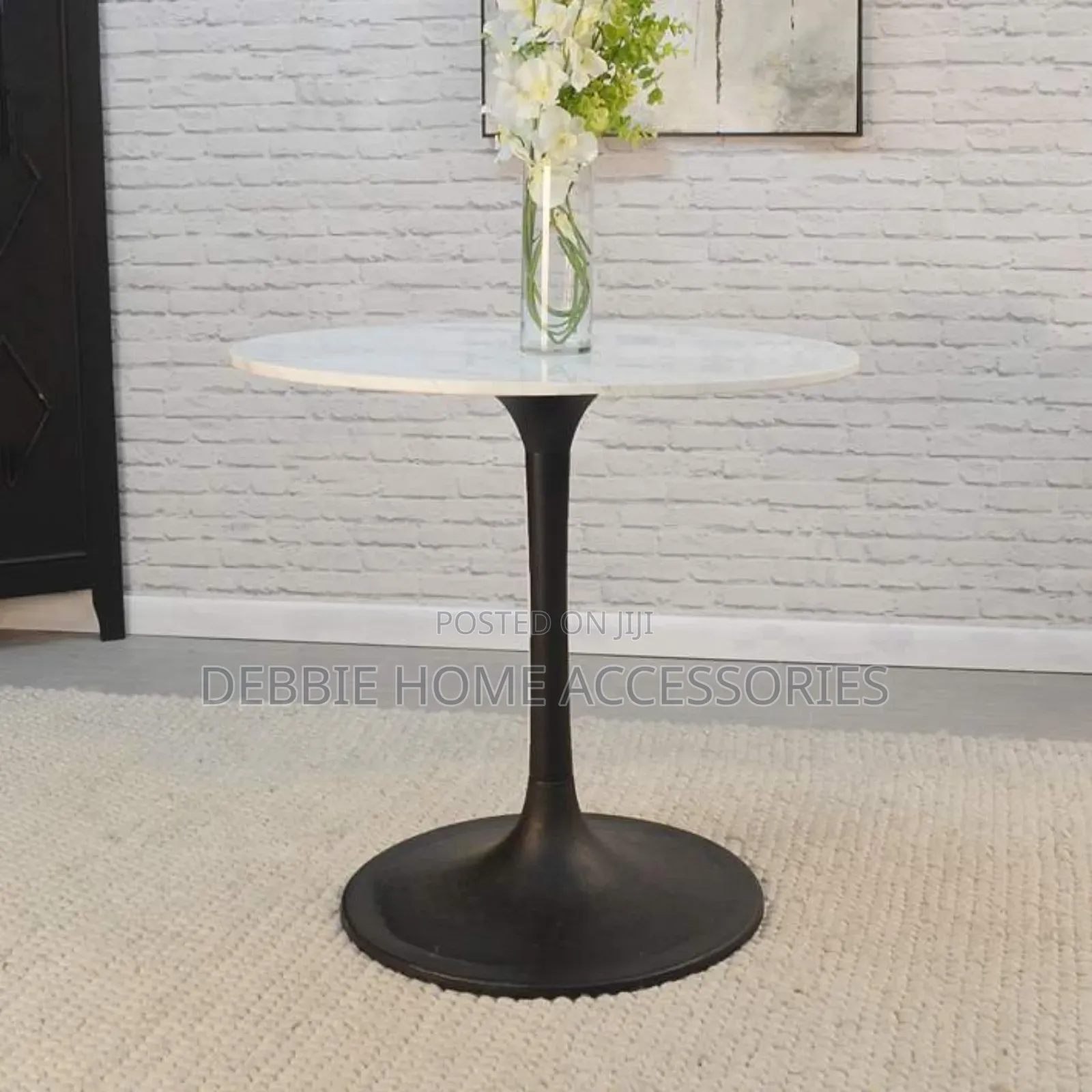 Round Dining Table With a White Marble Top and a Black Base.