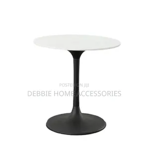 Round Dining Table With a White Marble Top and a Black Base.