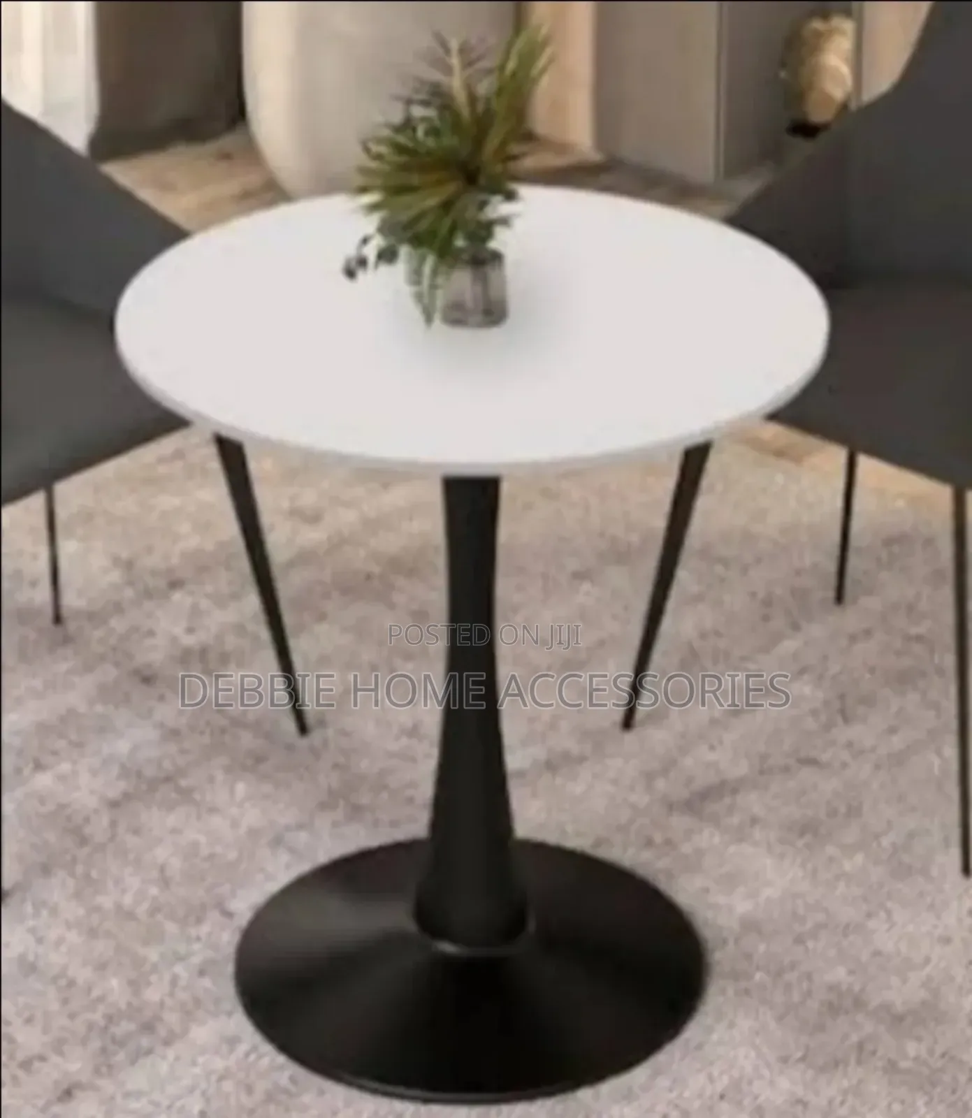 Round Dining Table With a White Marble Top and a Black Base.